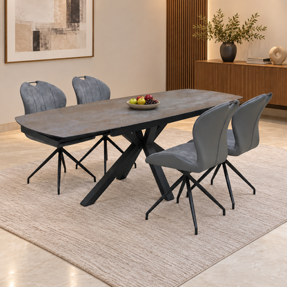 Raul titanium grey ceramic dining table and 4 grey swivel chairs in a dining room with a fruit bowl and rug