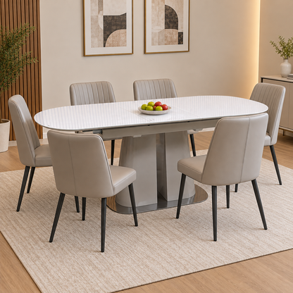 Cashmere white glass top extending dining table in a dining room with six grey chairs and a bowl of apples