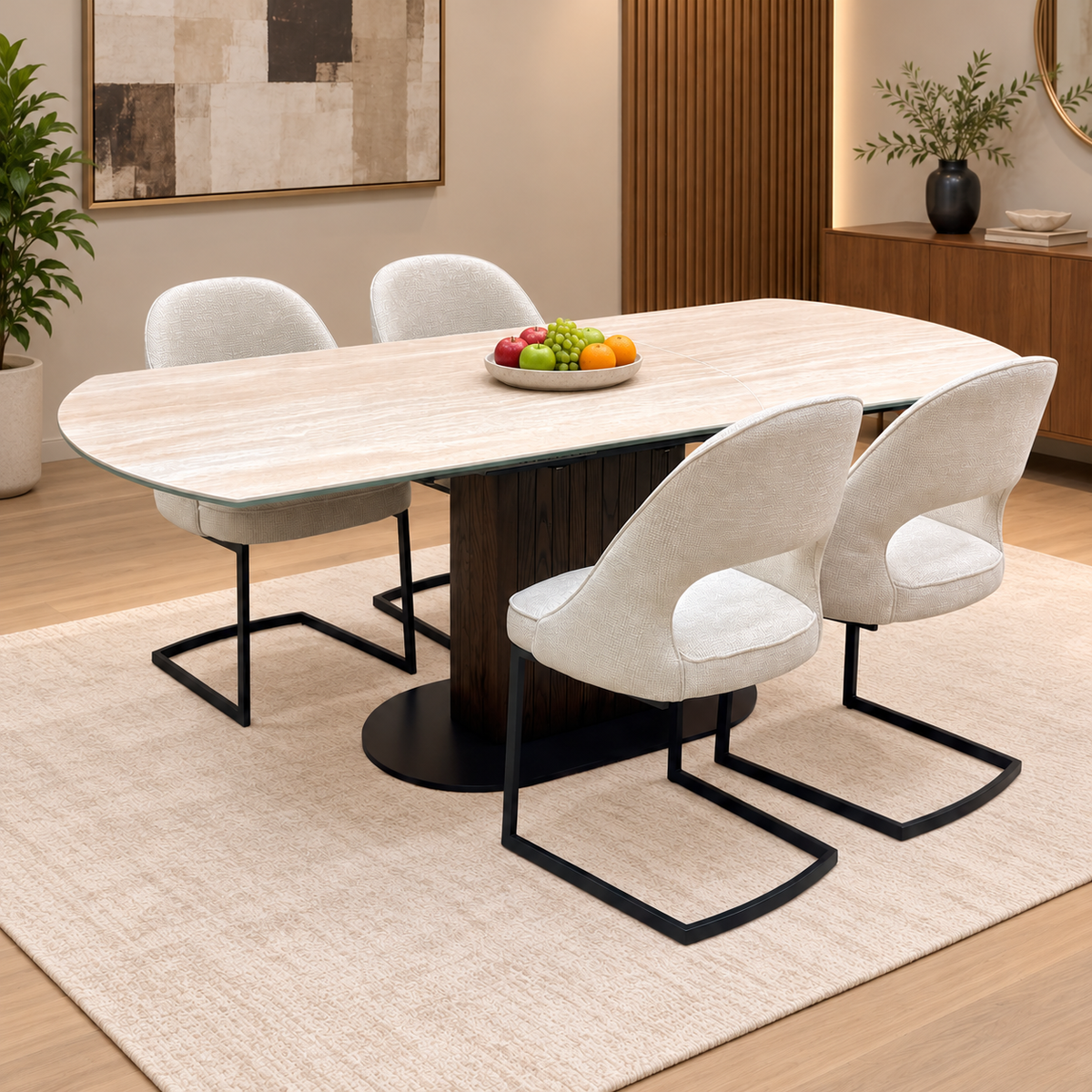 Tiber travertine ceramic dining table and beige cantilever chairs in a neutral dining room with a bowl of fruit