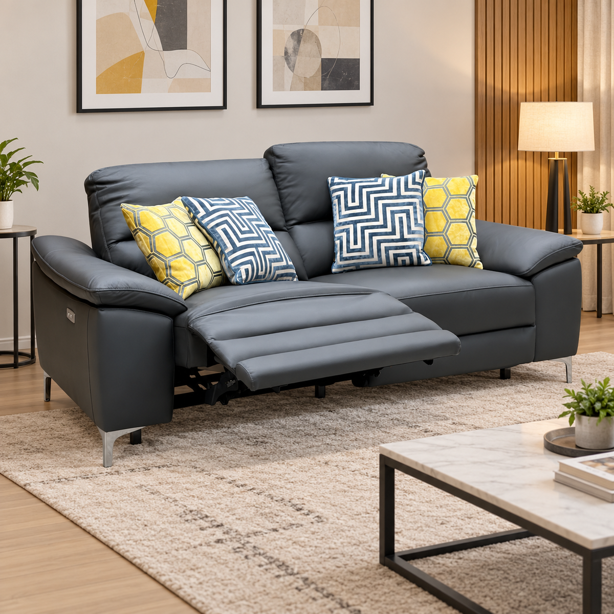 Pavillion charcoal grey leather 3 seater power recliner sofa reclined in a living room with a marble coffee table