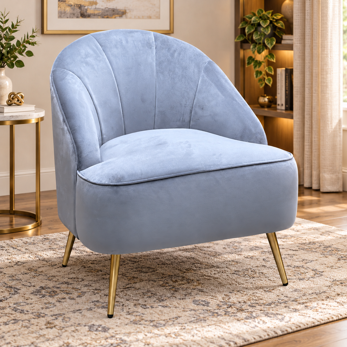 Cali bluish grey velvet accent chair in a living room beside a gold side table on a patterned rug