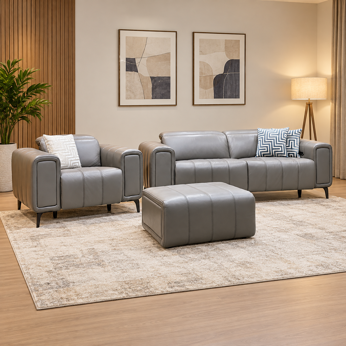 Elphaba elephant grey leather sofa, chair and footstool in a living room with abstract prints, floor lamp and patterned rug