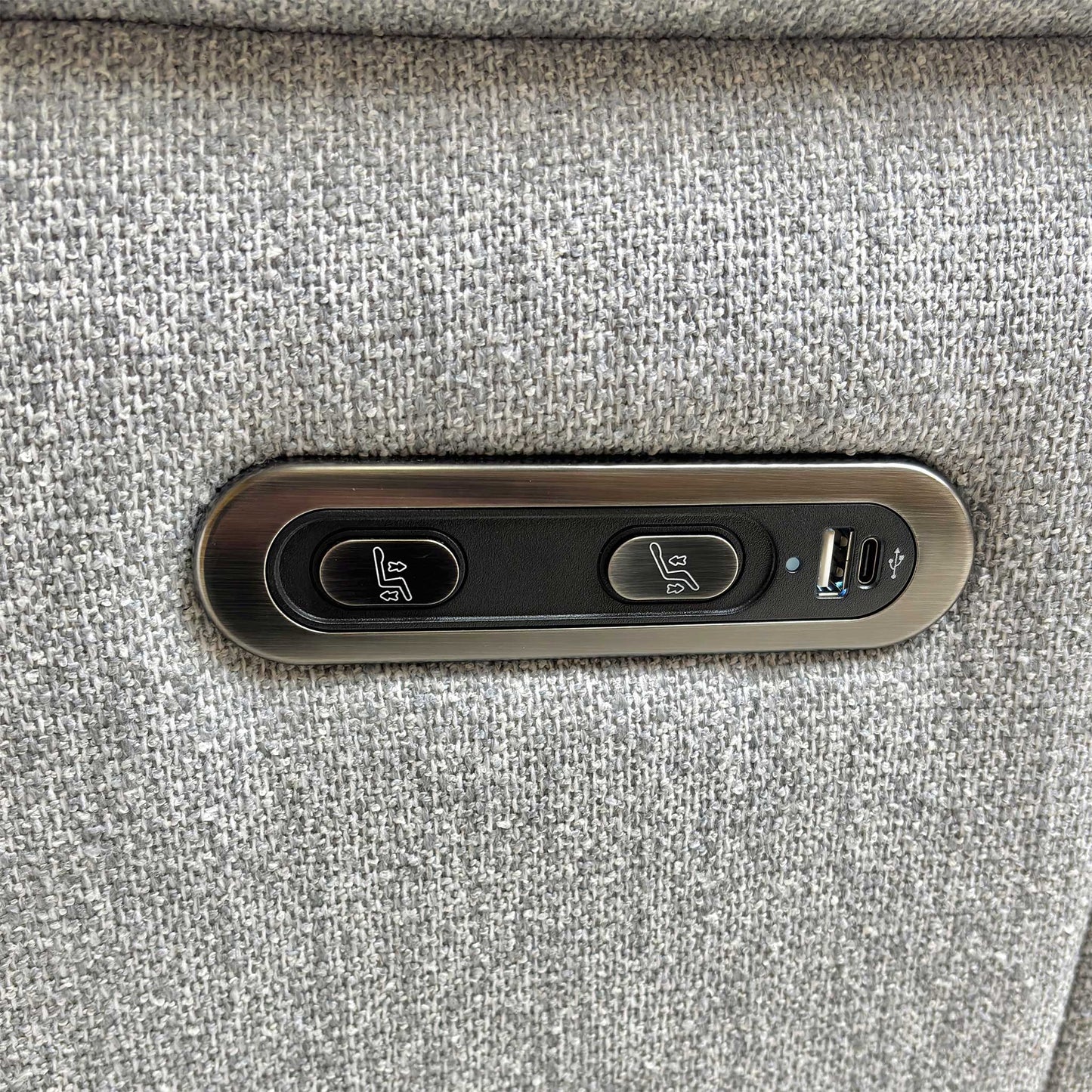 Close-up of the integrated power reclining control buttons on the side of the ‘Bobby’ Florence Stone Grey fabric sofa, showing the motorized adjustment switches.