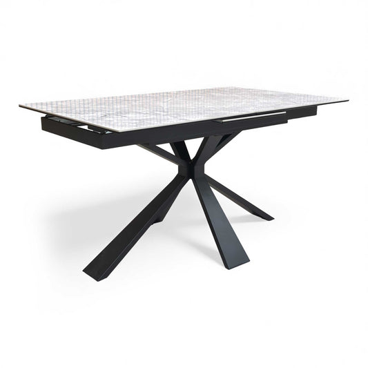 Full view of 'Crete' 140cm small extending dining table with a white high-gloss ceramic top and black powder-coated metal legs.