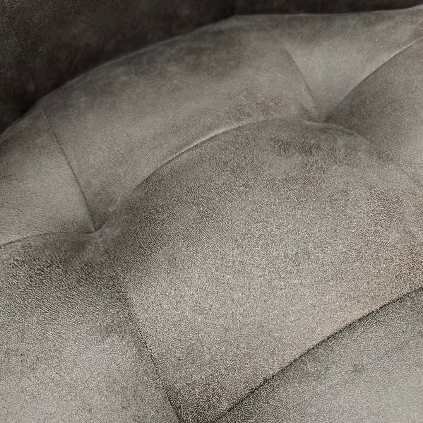 Detailed shot of the premium charcoal grey suede upholstery and soft-touch textured finish.