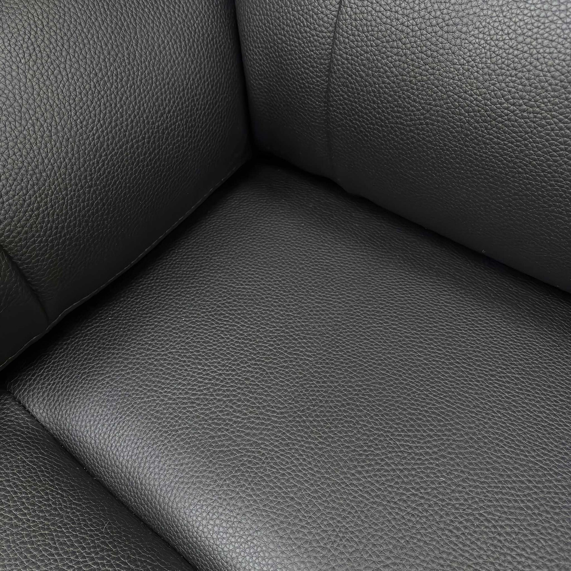 Close-up of the black faux leather upholstery, highlighting the durable, easy-clean finish and quality stitching.