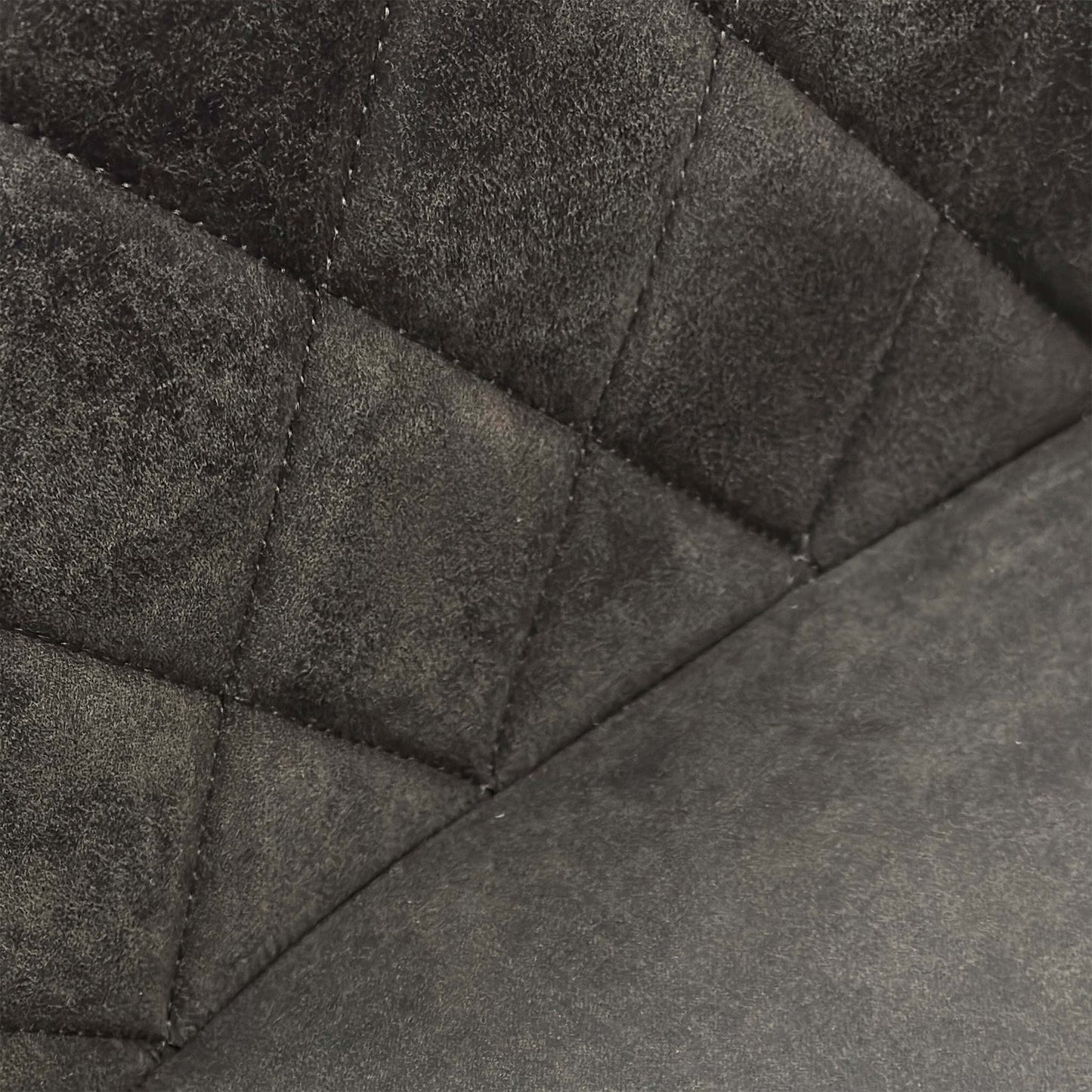 Close-up of the grey fabric upholstery on the Warrior chair, showcasing the intricate quilted-effect decorative stitching.