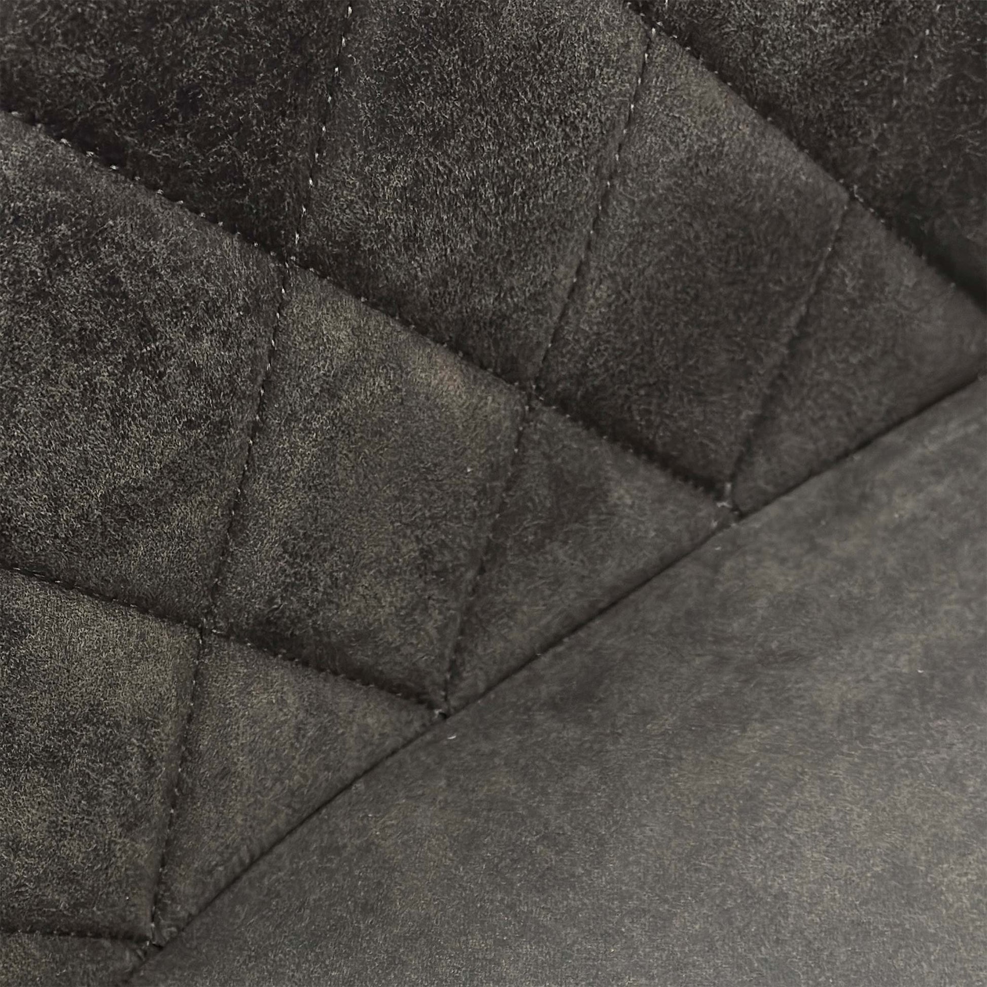 Close-up of the grey fabric upholstery on the Warrior chair, showcasing the intricate quilted-effect decorative stitching.
