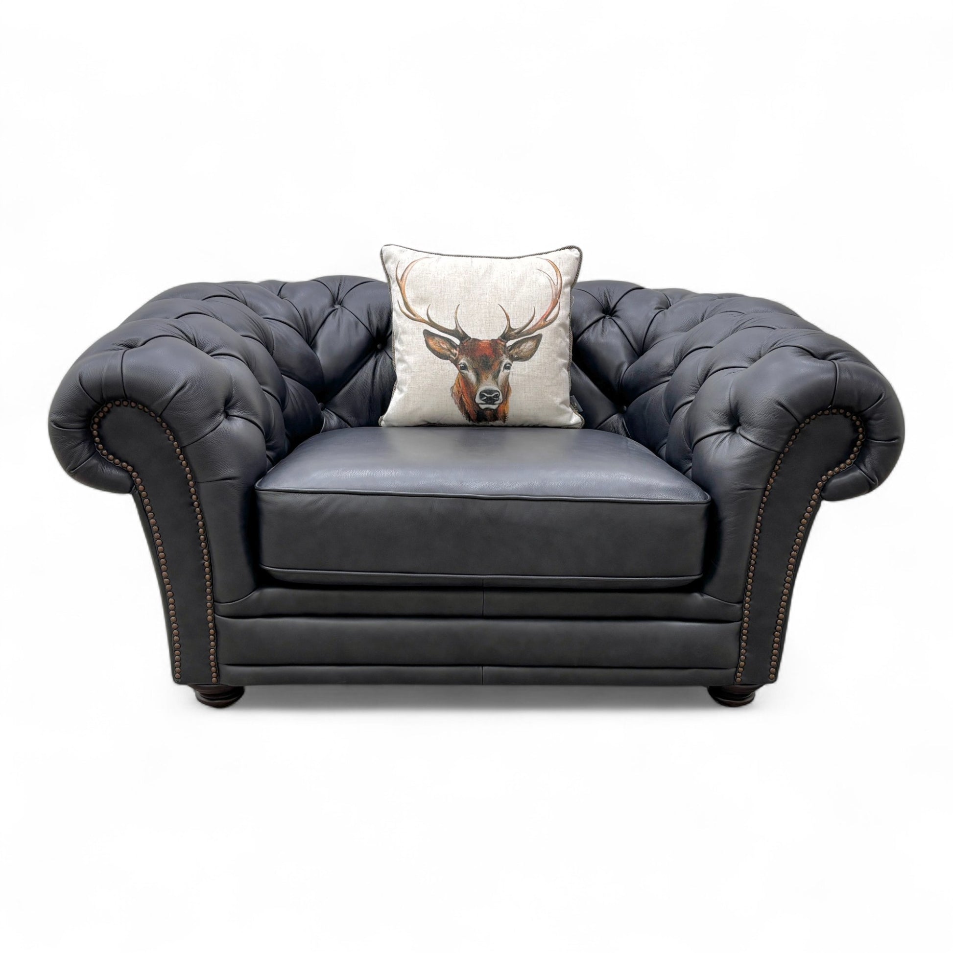 Close-up of the navy blue leather upholstery on the 'Savannah' snuggler chair, emphasizing the smooth texture and solid color.