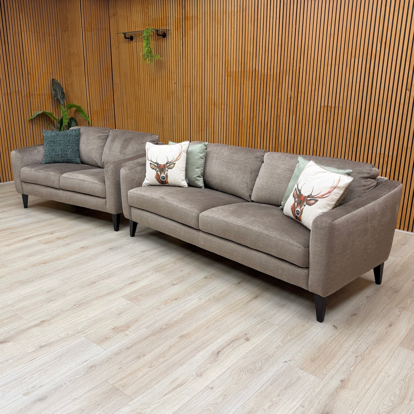 Lifestyle view of the compact Oslo Vogue 2-seater fabric sofa in stone grey velvet, featuring plush fixed back cushions and a streamlined frame.
