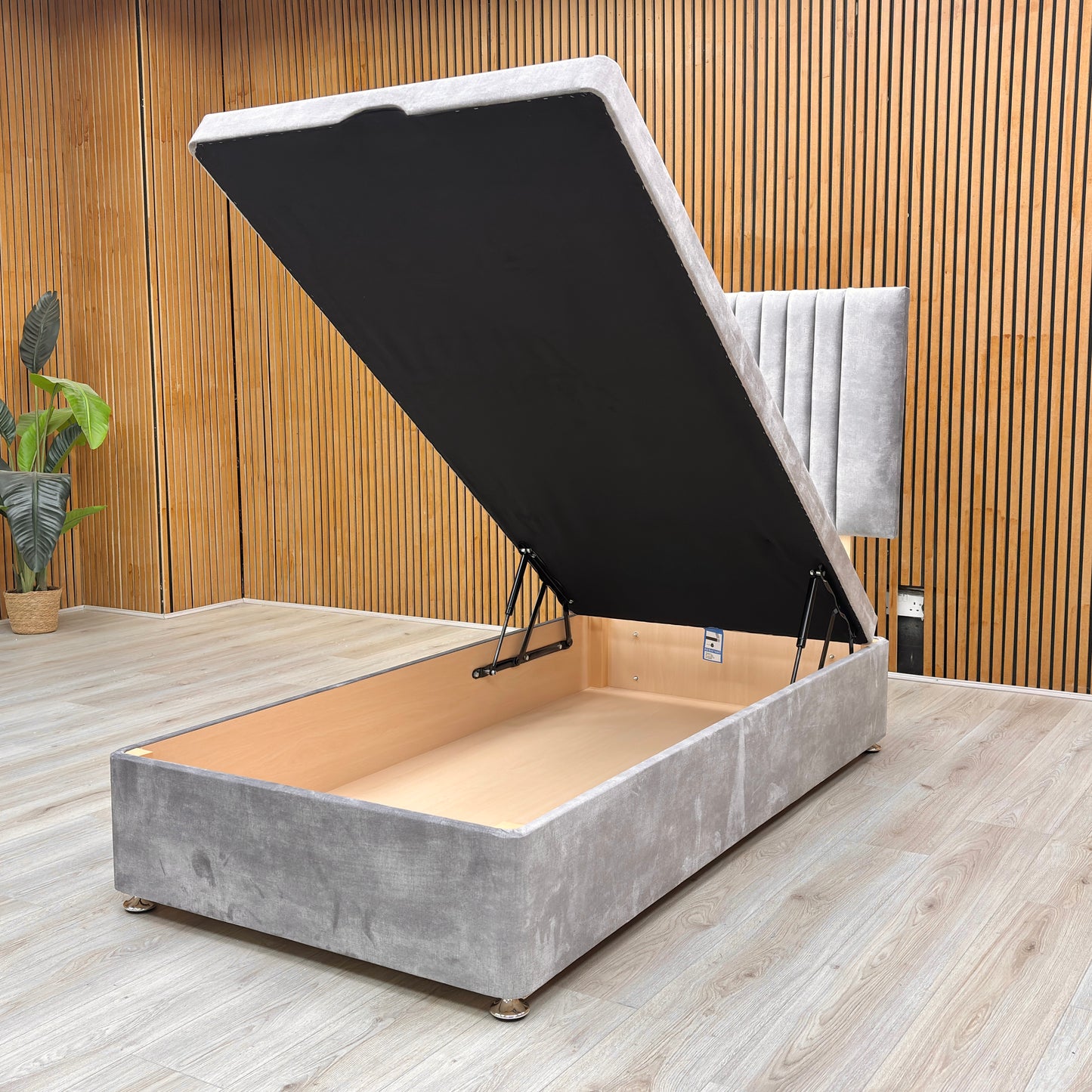Detail view of the end-lift ottoman base in its open position, demonstrating the vast under-bed storage space for linens and essentials.