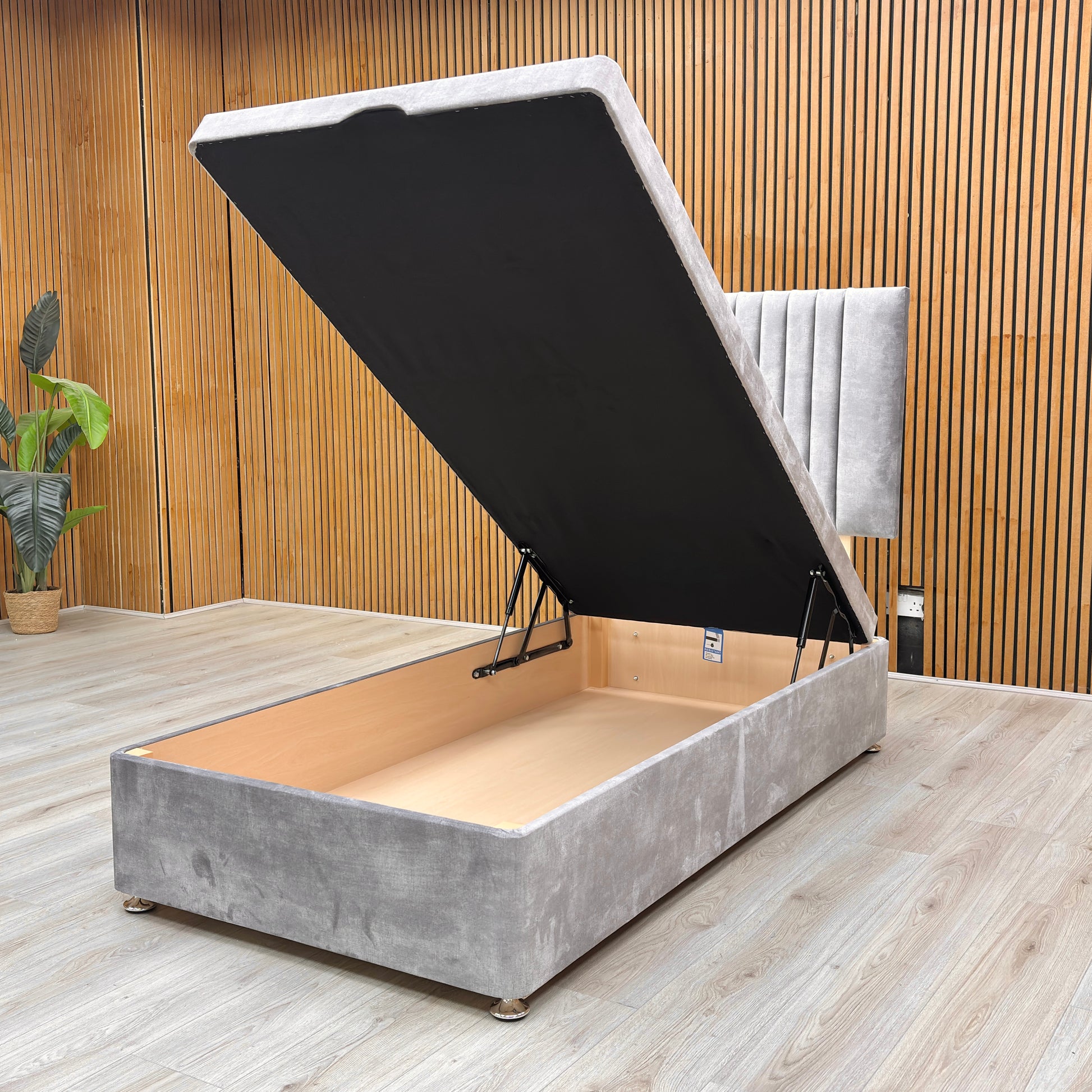 Detail view of the end-lift ottoman base in its open position, demonstrating the vast under-bed storage space for linens and essentials.