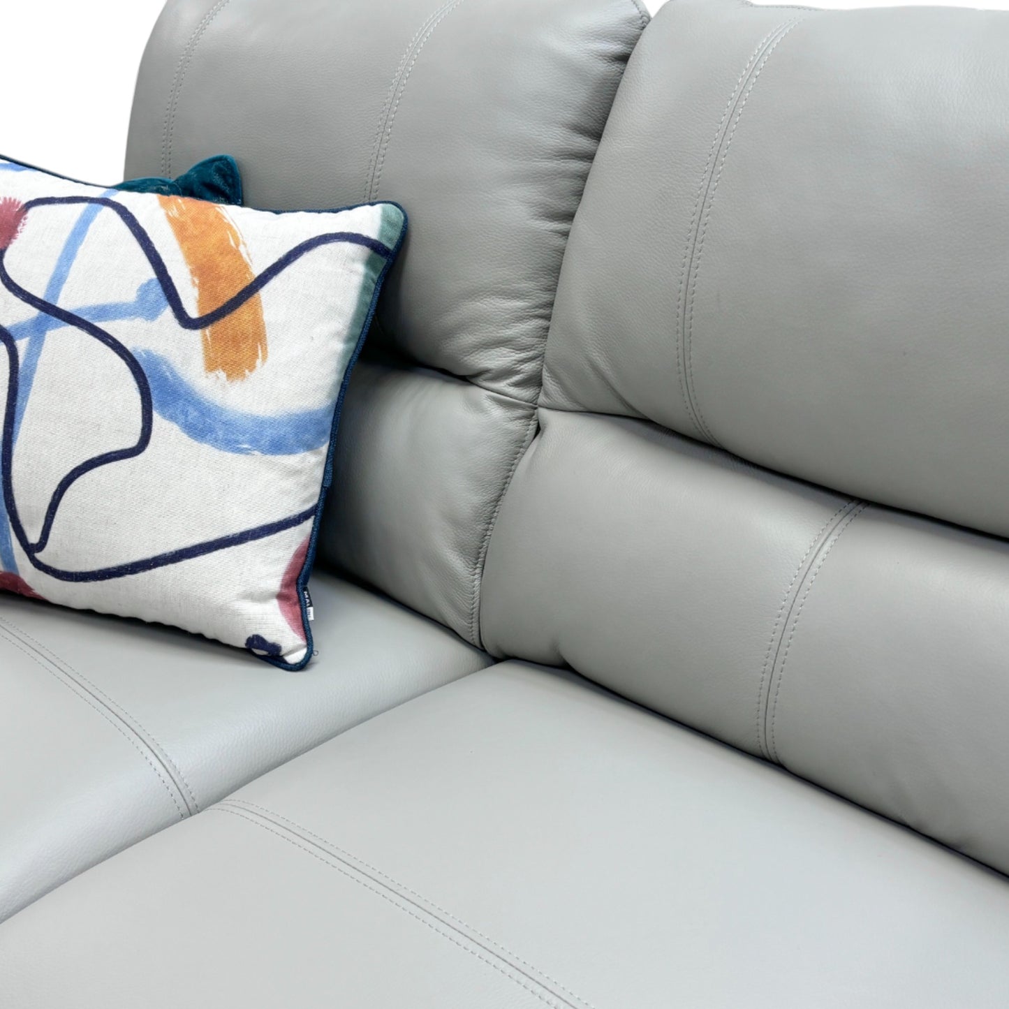 Close-up detail of the 'Winner' sofa's seat and back cushions, showing the quality light grey leather and the stitching detail on the rolled armrest.