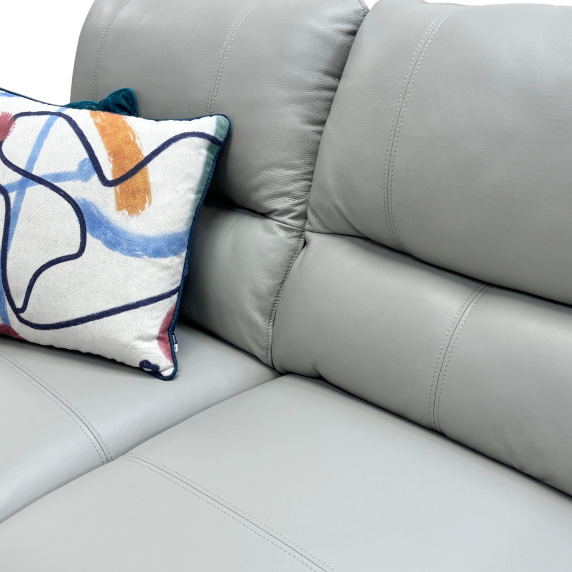 Close-up detail of the 'Winner' sofa's seat and back cushions, showing the quality light grey leather and the stitching detail on the rolled armrest.