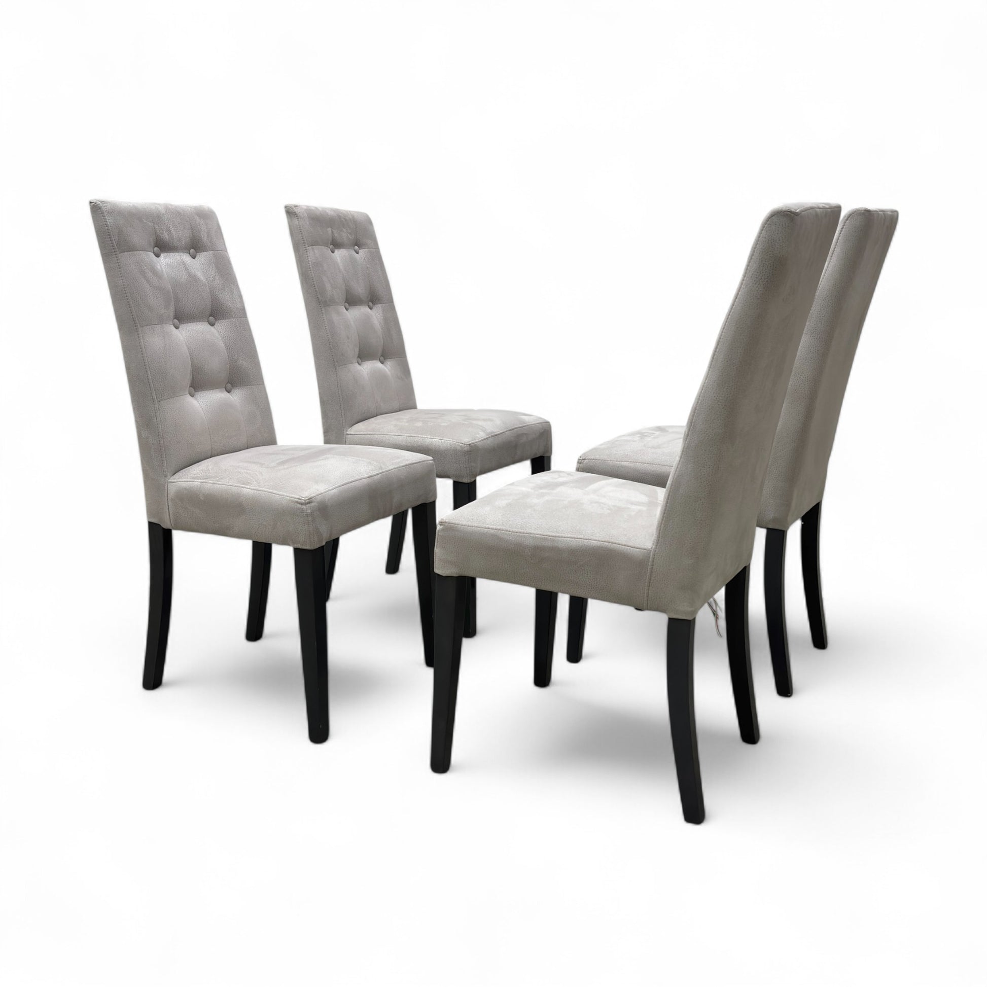 Angled view of the 'Mia' Silver Suede High Back Dining Chair, highlighting the silver suede texture, tufted back, and medium wood tone legs.