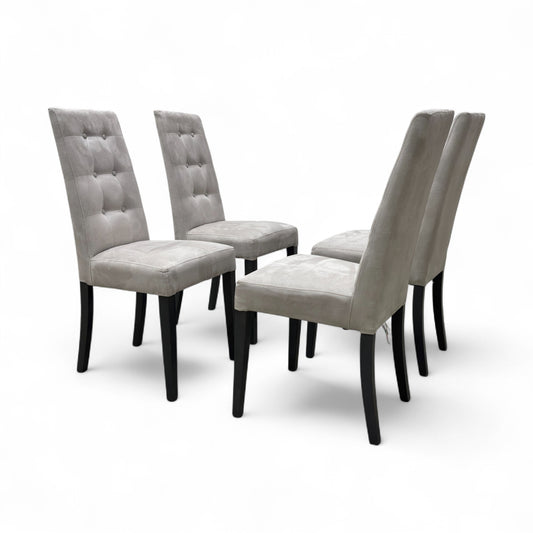 Angled view of the 'Mia' Silver Suede High Back Dining Chair, highlighting the silver suede texture, tufted back, and medium wood tone legs.