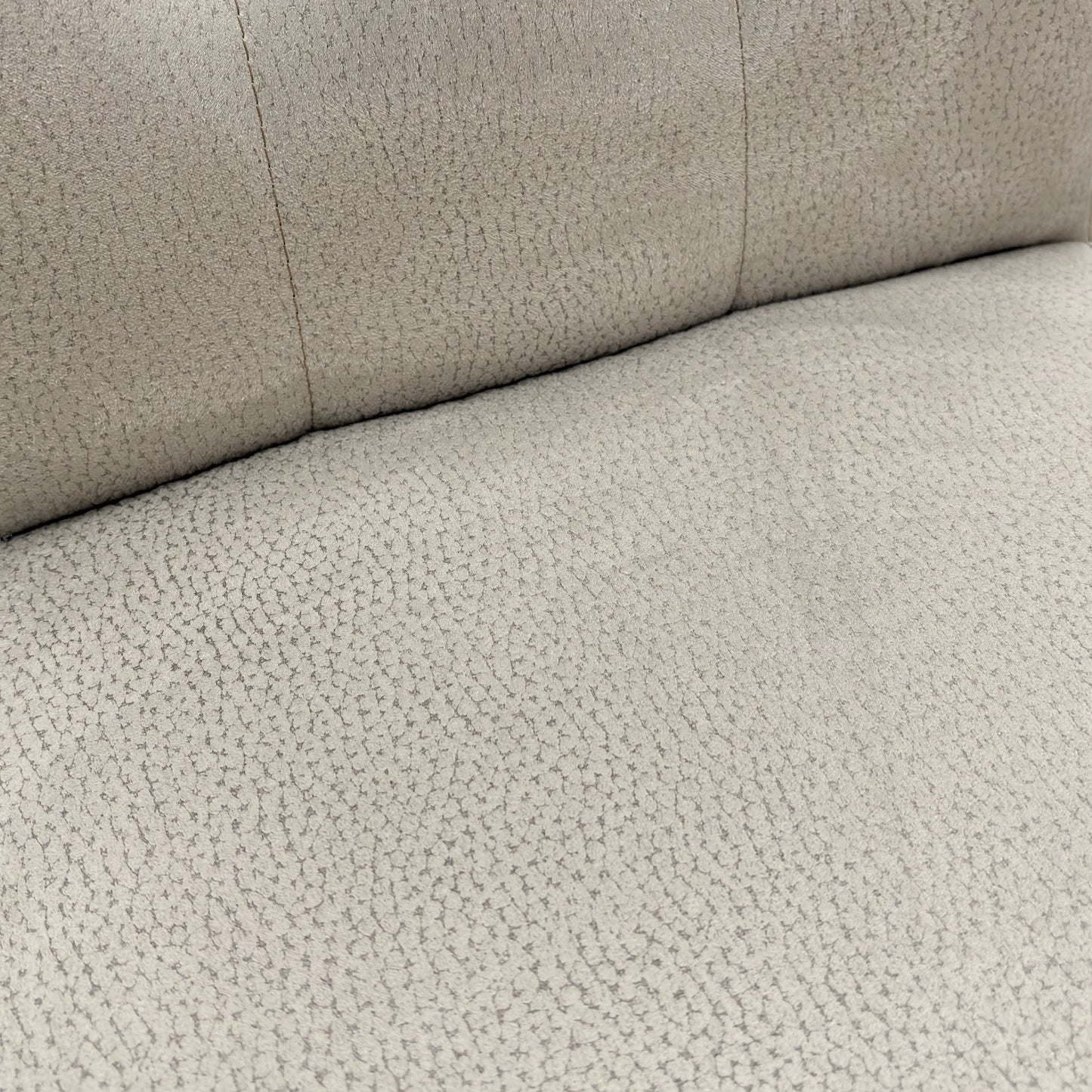 Close-up view of the button-tufting detail on the high back of the 'Mia' silver suede dining chair.