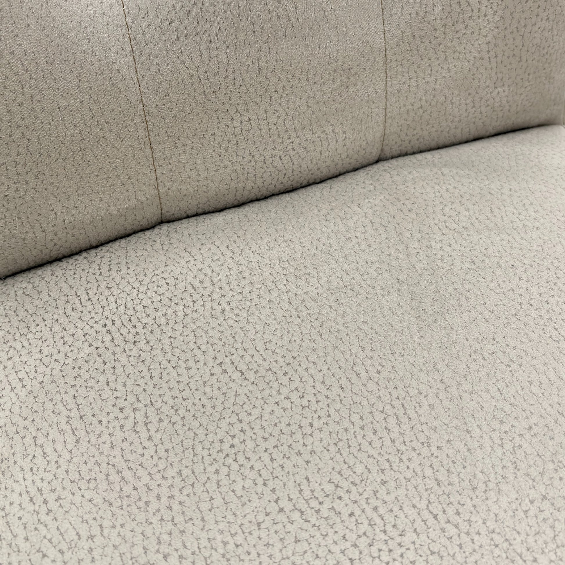Close-up view of the button-tufting detail on the high back of the 'Mia' silver suede dining chair.