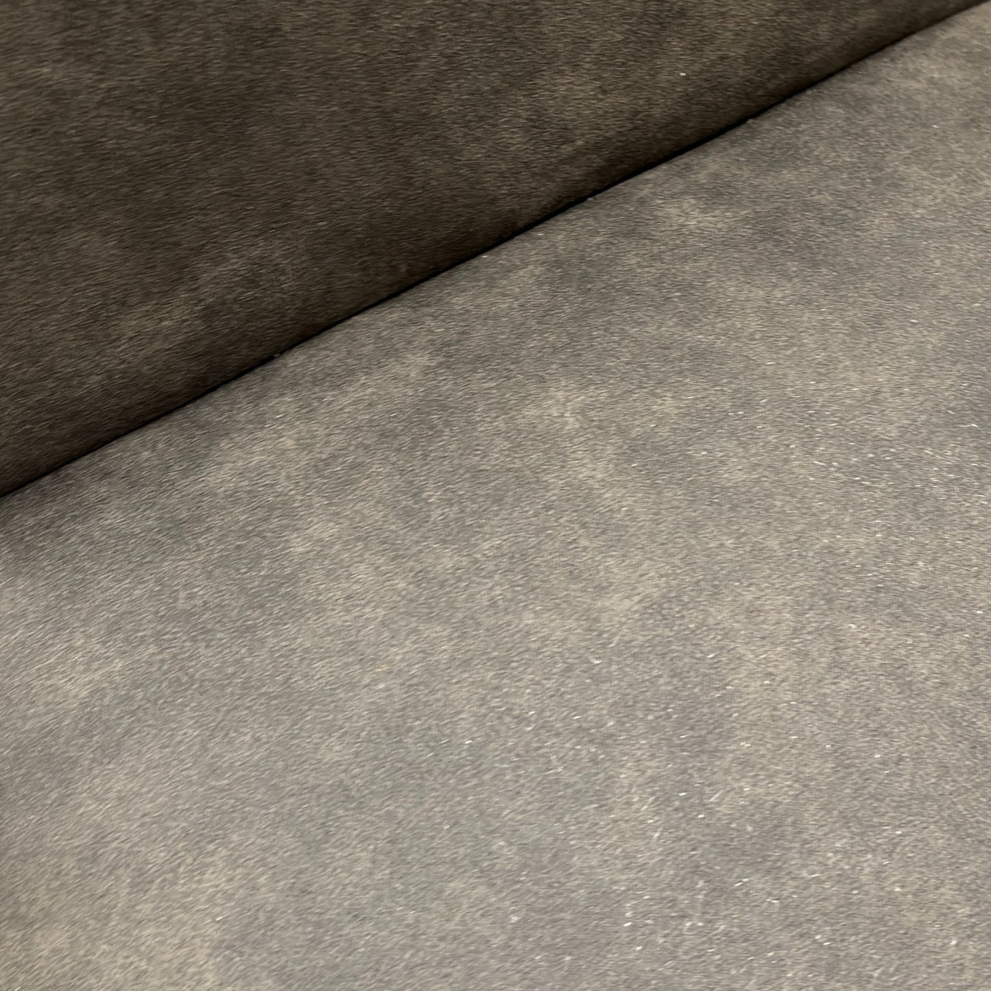 Close-up detail of the grey "Cowboy" suede fabric, showing the texture and stitching on the upholstered back of the Augusta chair.