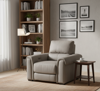 Beige armchair in a living room with a bookshelf and framed pictures on the wall.