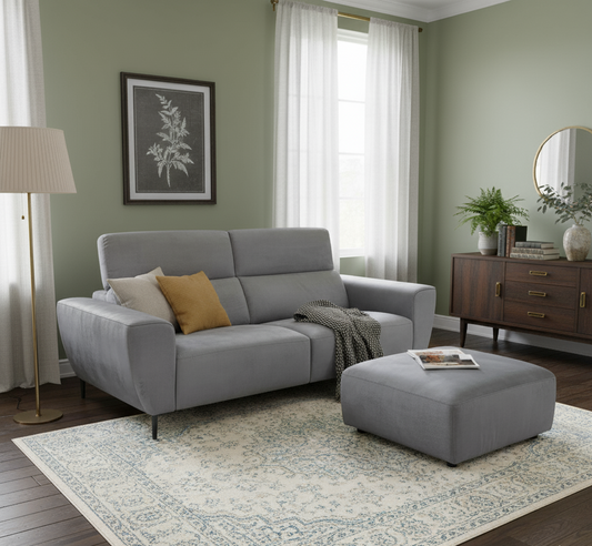Gray sofa with cushions and an ottoman in a living room setting.