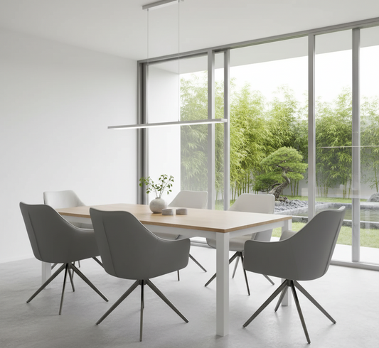 Modern dining area with a wooden table and gray chairs in a bright room with large windows.