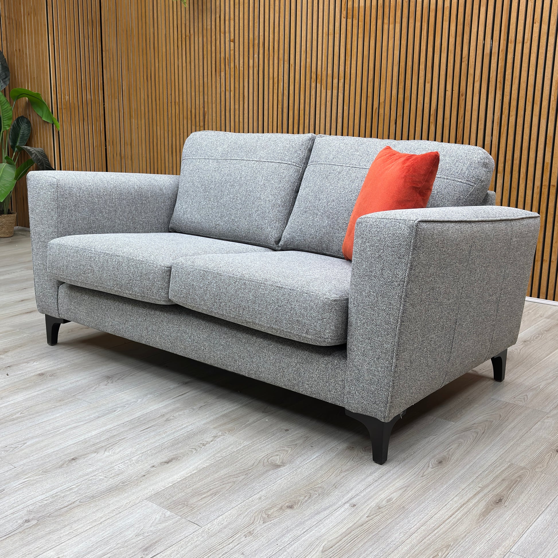 Lifestyle shot of the ‘Lille’ silver fabric sofa, showcasing the structured cushions and silver grey fabric.
