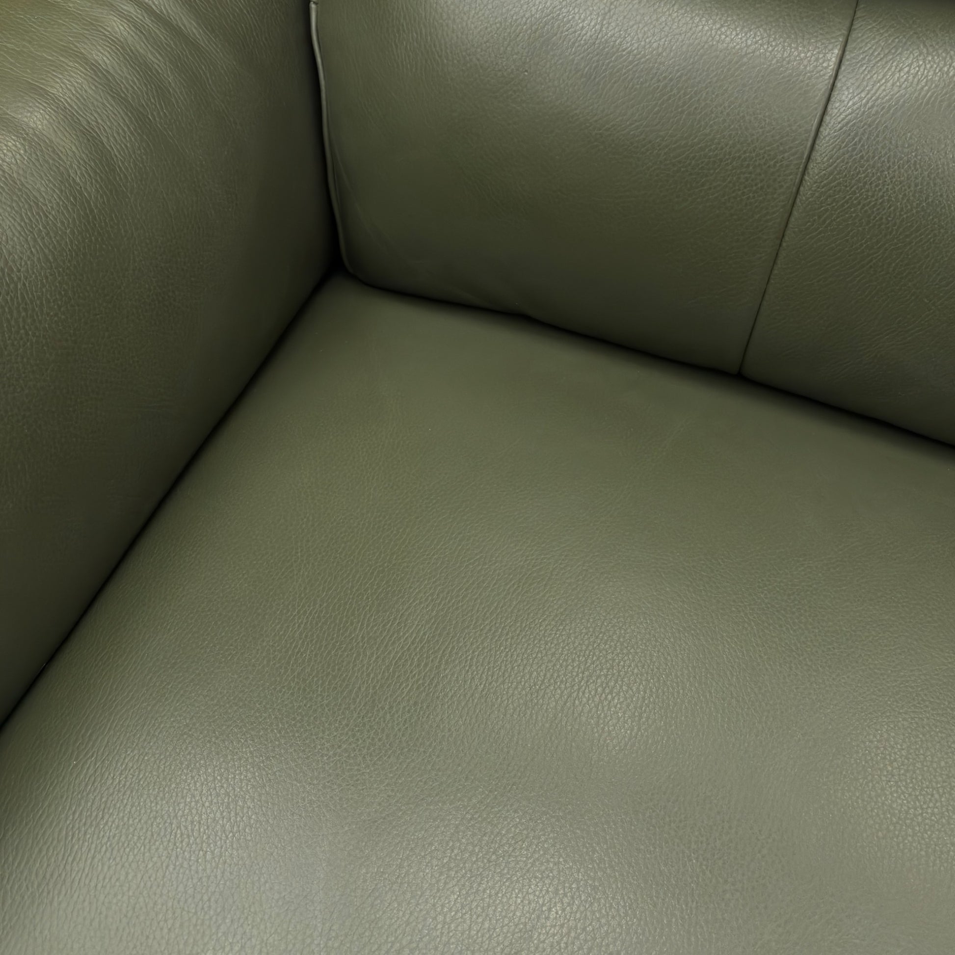Close-up detail of the high-quality Oslo Pine Green leather upholstery on the 'Daytona' sofa, showing the fine grain and contrast stitching.