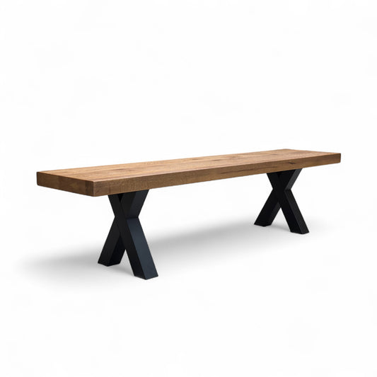 Full, angled view of the Bodahl Njord 180cm Dining Bench, featuring a Desert Solid Oak seat top and modern black metal X-shaped legs.