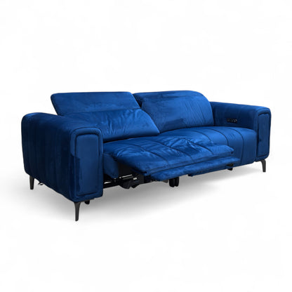 Angled view of the Elphaba 3 Seater Power Recliner Sofa in Royal Blue Velvet, showcasing its modern design and storage arms.