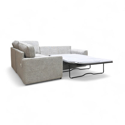 Side view of the 'Emilia' Silver Woven Fabric Corner Sofa, showing the armrests and overall structure.