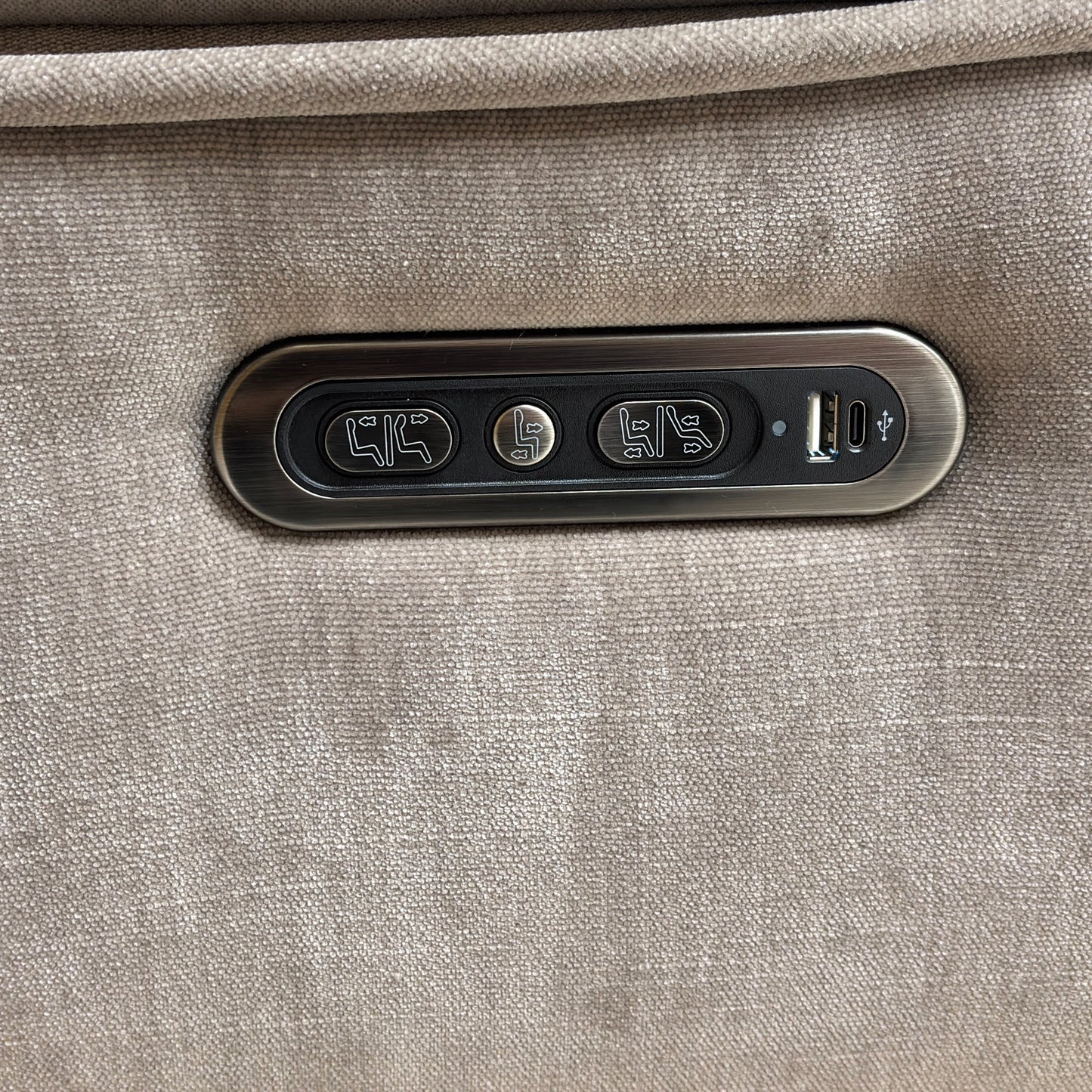 Detailed close-up of the discreet control panel, showing the power recline and power headrest buttons, along with the integrated USB charging port.