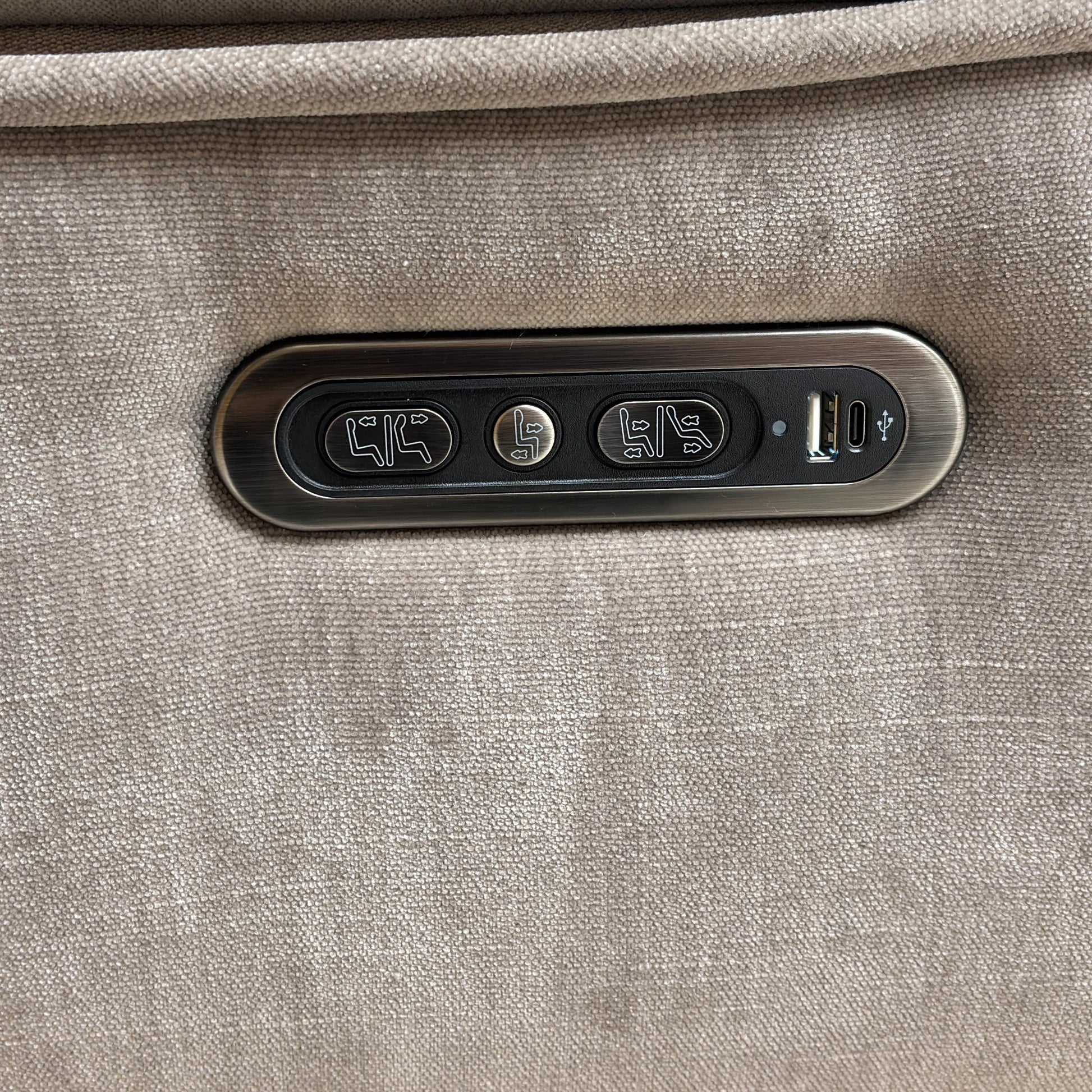 Detailed close-up of the discreet control panel, showing the power recline and power headrest buttons, along with the integrated USB charging port.