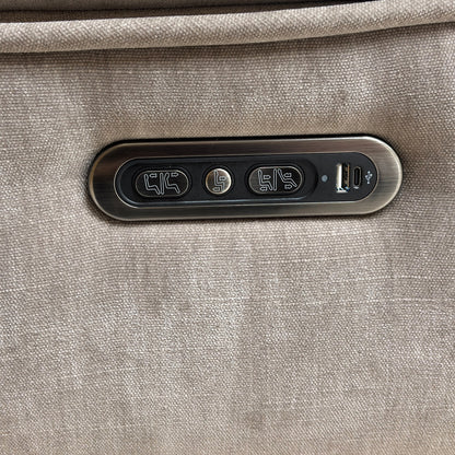 Detailed close-up of the discreet control panel, showing the power recline and power headrest buttons, along with the integrated USB charging port.