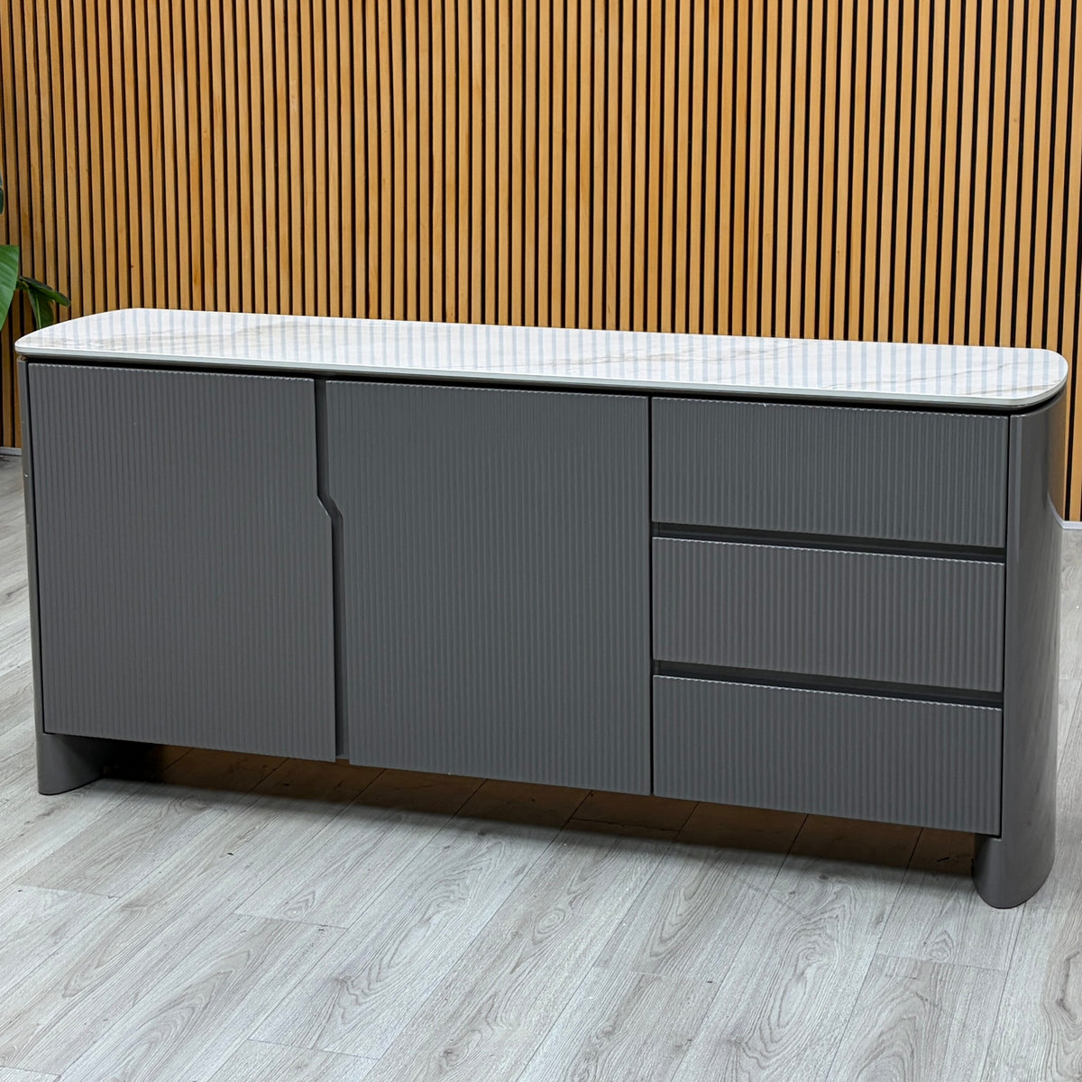 Ivy grey high gloss sideboard with white ceramic top against a slatted wooden wall on a grey wood-effect floor