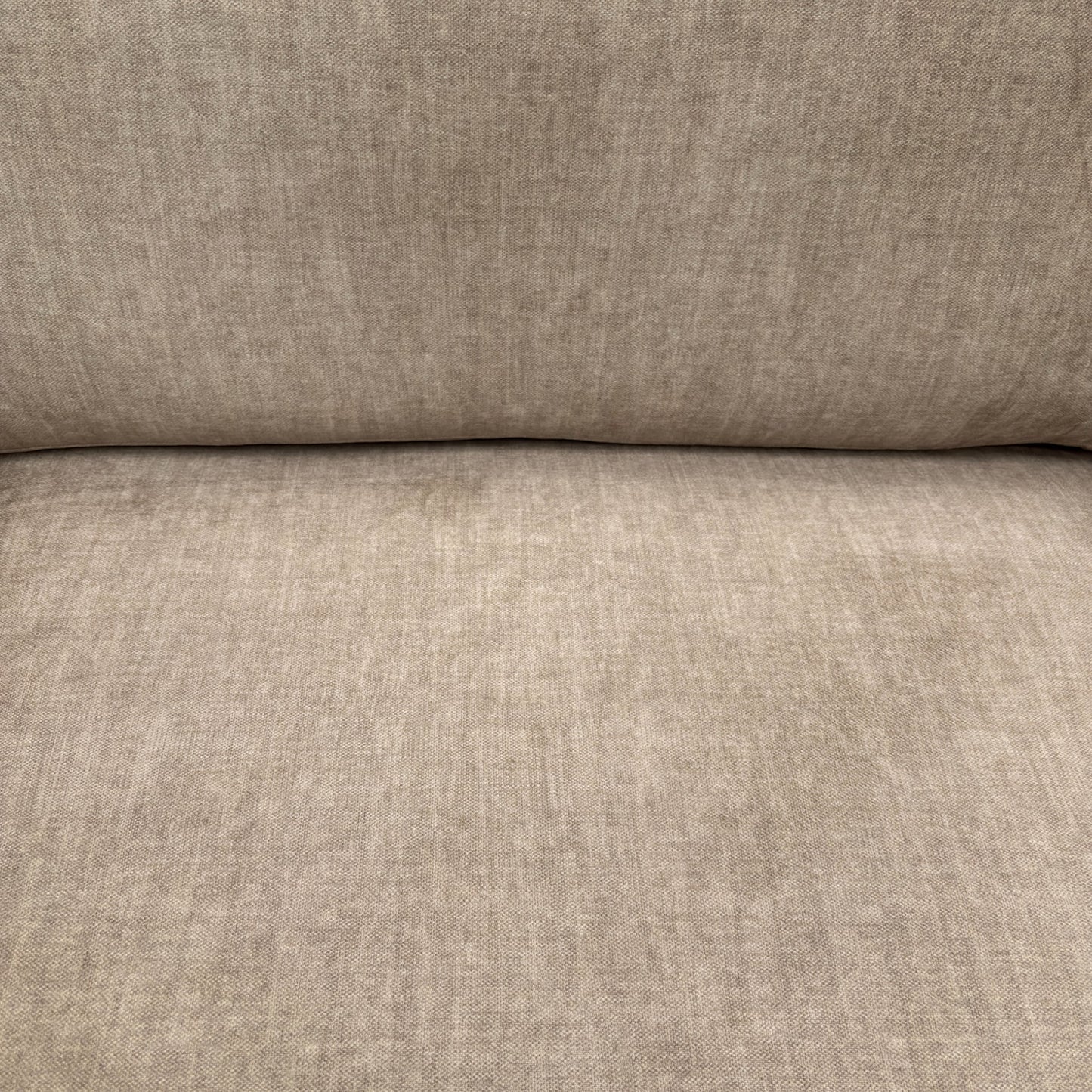 Close-up of the soft beige fabric upholstery of the Chelsea sofa, showcasing its luxurious texture and quality material.