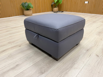 Lifestyle view of the Cozee storage footstool in a living room setting, highlighting its rich color and versatile use.