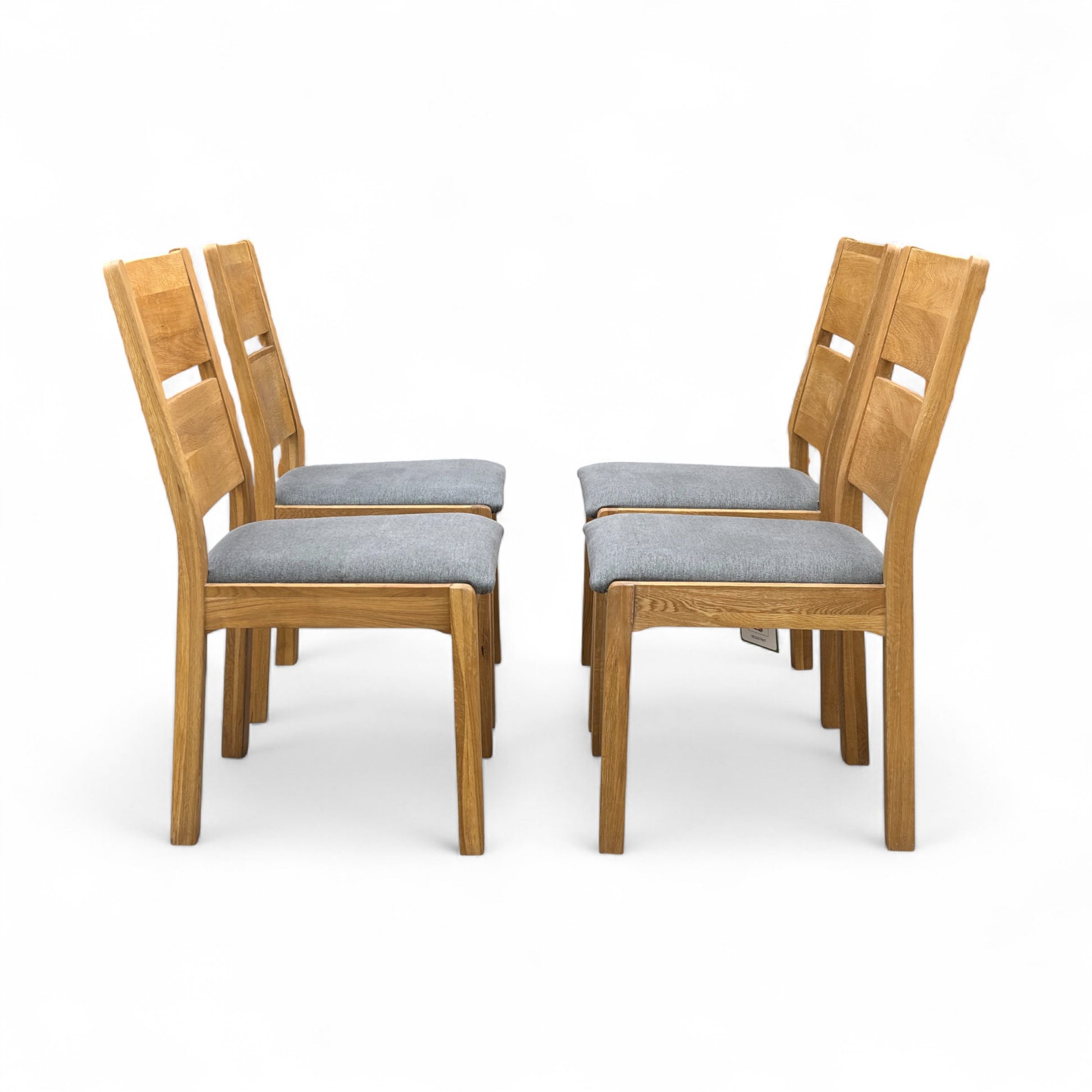 Angled view of the 'Bakerloo' chair, emphasizing the shape of the dark wooden backrest and the comfortable upholstered seat.