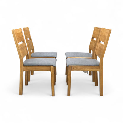 Angled view of the 'Bakerloo' chair, emphasizing the shape of the dark wooden backrest and the comfortable upholstered seat.