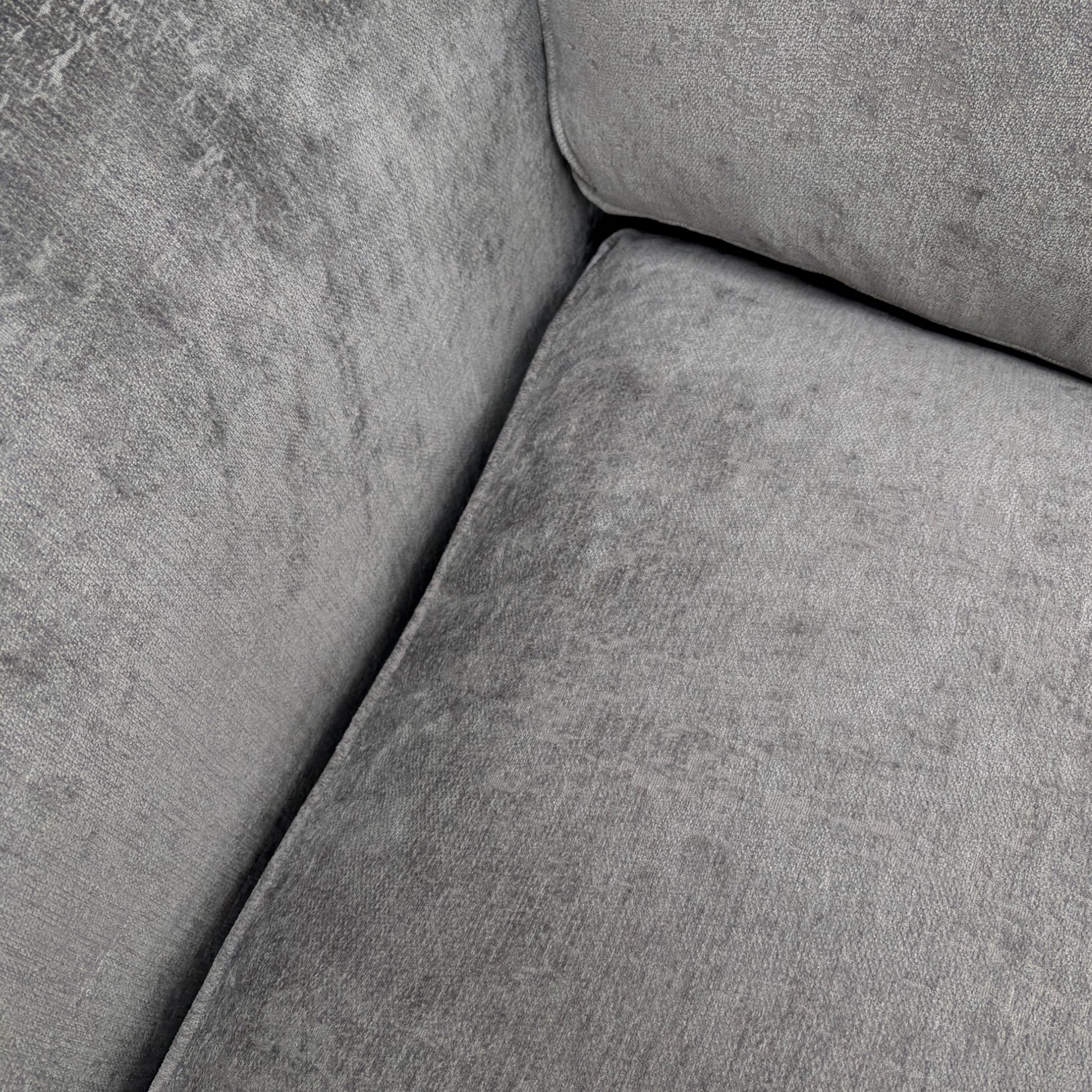 Close-up of the chenille fabric texture, stitching, or a cushion detail.