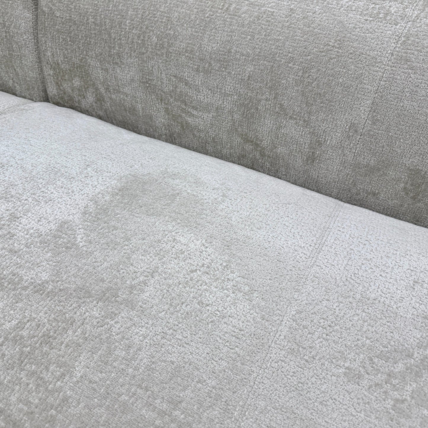 Close-up texture detail of the soft turtledove grey chenille fabric upholstery on the 'Los Angeles' sofa.