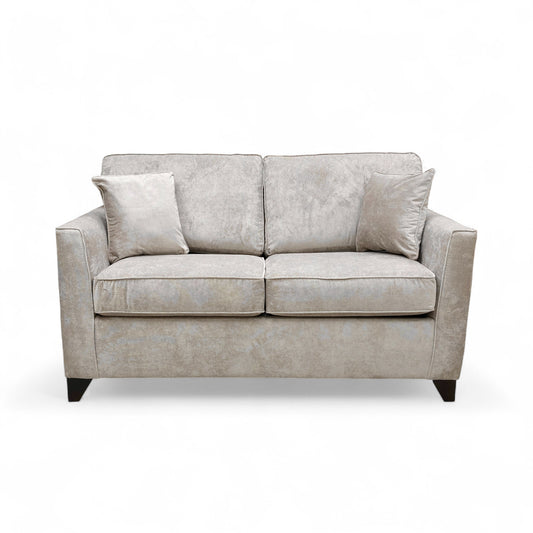 Frontal view of the ‘Smith’ Mink Fabric Sofa, highlighting the two-seater size, sloped armrests, and two back cushions.