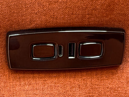 Close-up texture shot of the plush rust orange velvet upholstery on the 'Ezra' power recliner chair.