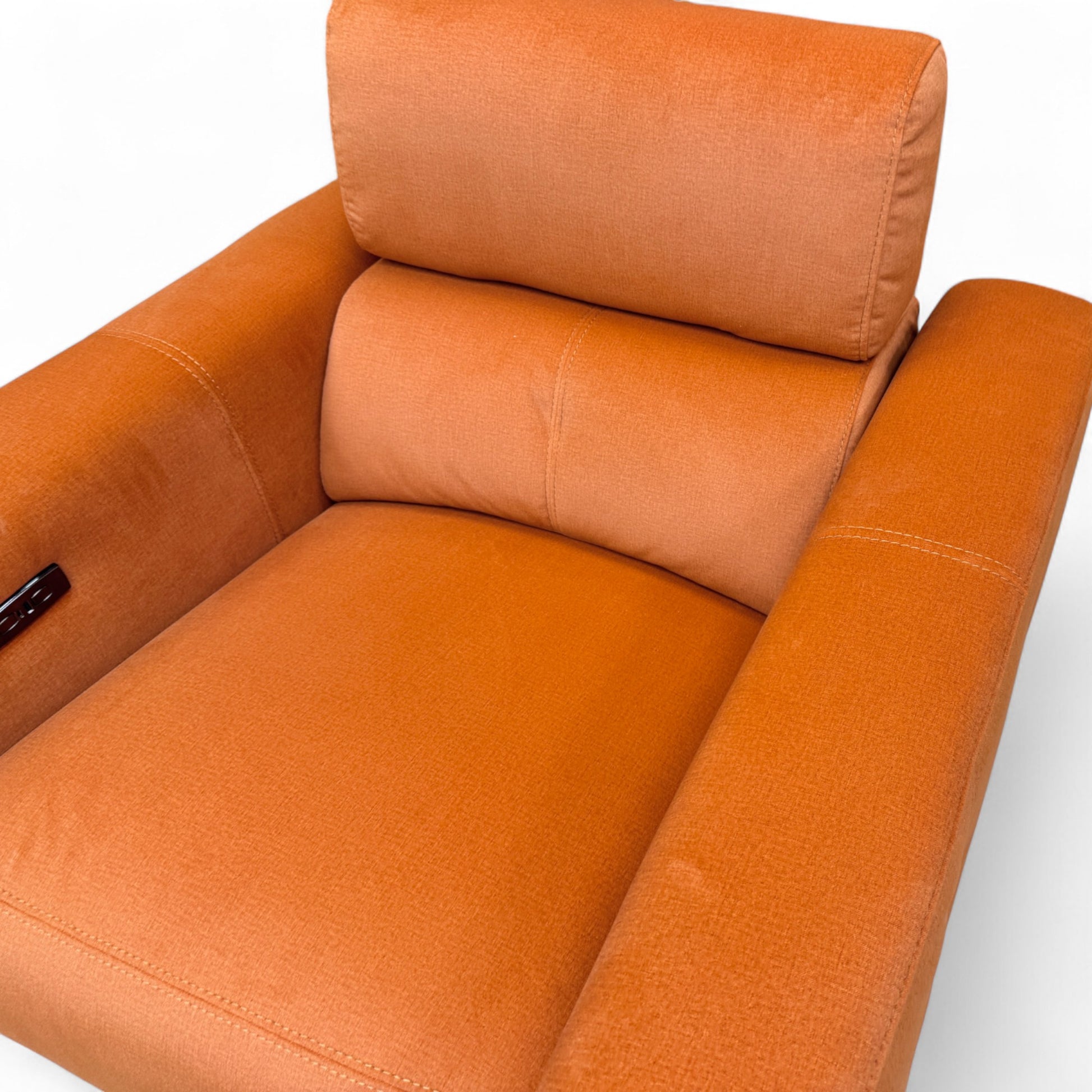 Close-up texture shot of the plush rust orange velvet upholstery on the 'Ezra' power recliner chair.