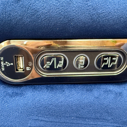 Close-up of the power control panel on the 'Cora' recliner, showing the buttons for the power recline and adjustable power headrest.