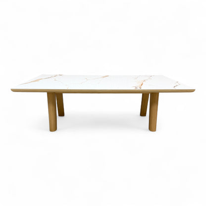 front side view of the 'Montreale' dining table, highlighting the glossy white ceramic surface and the thickness of the tabletop