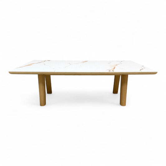 front side view of the 'Montreale' dining table, highlighting the glossy white ceramic surface and the thickness of the tabletop