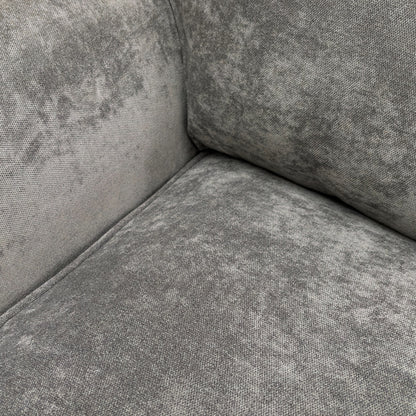 A close-up shot focusing on the texture of the grey fabric and the detail of the stitching on the cushions and arms.