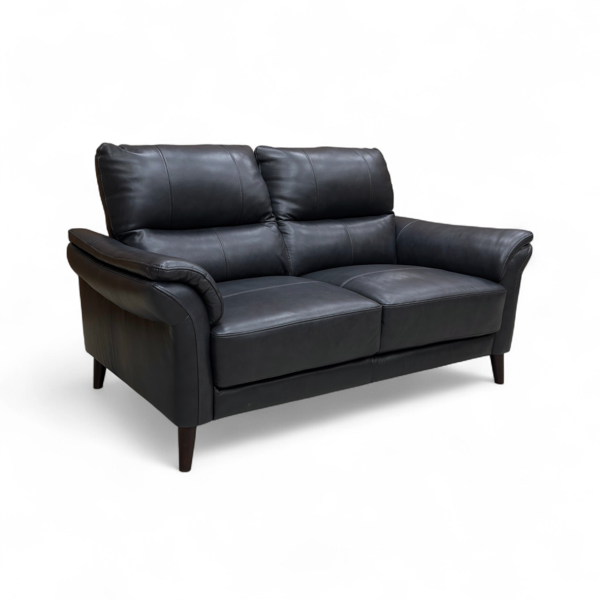 A full shot, possibly a styled lifestyle image of the navy leather sofa in a room setting.
