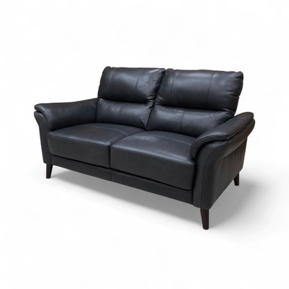 A view focusing on the tapered wooden legs and the bottom portion of the sofa.